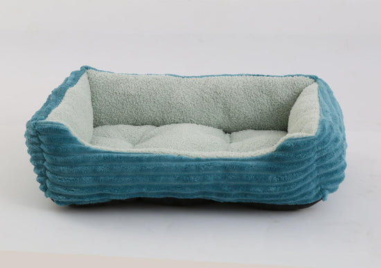 Luxury pet bed with padded cushion, featuring a stylish blue corduroy fabric outside and a fluffy green lining.